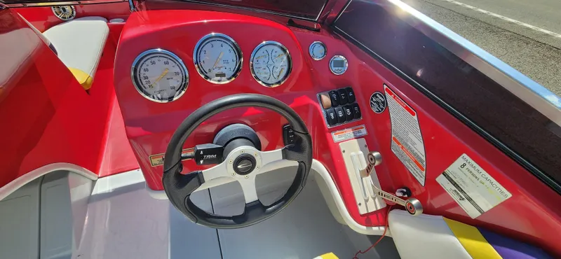 Slide: The Image of 2005 Baja 202 Islander boat dashboard with steering wheel and gauges. - 14