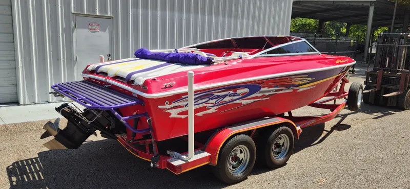Slide: The Image of Red 2005 Baja 202 Islander speedboat on trailer, vibrant graphics, parked outdoors. - 5