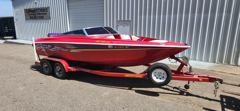 Slide: The Image of Red 2005 Baja 202 Islander speedboat on trailer, parked outside metal building. - 7