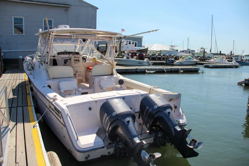 Slide: The Image of 2003 Grady-White Express 330 boat docked at marina with twin outboard engines. - 1