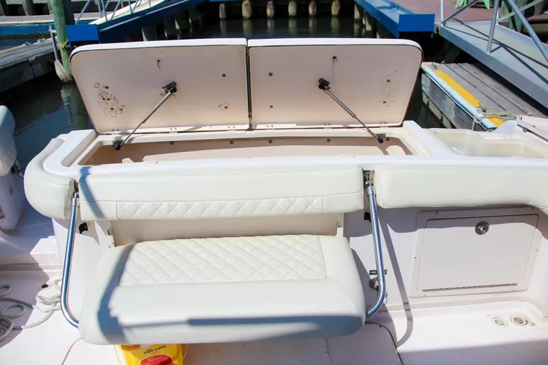 Slide: The Image of 2003 Grady-White Express 330 boat interior with open storage compartments and cushioned seating. - 10