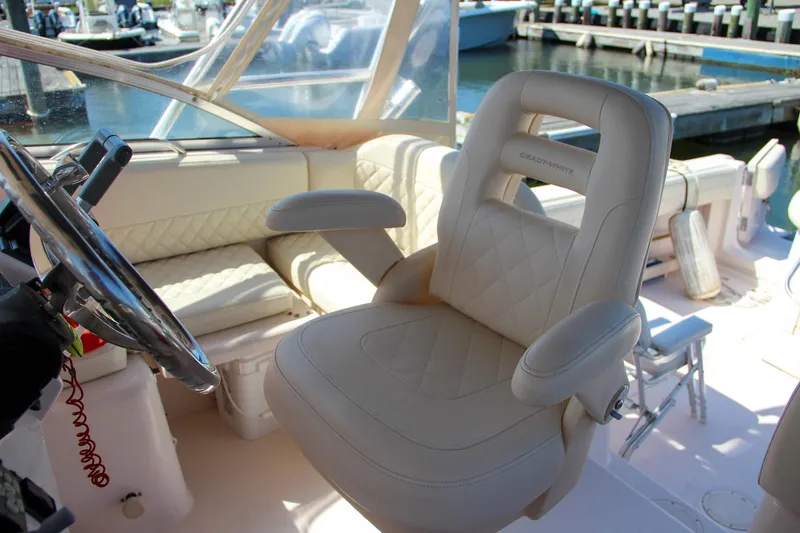 Slide: The Image of Luxurious helm seat on 2003 Grady-White Express 330 boat, featuring plush white upholstery. - 20