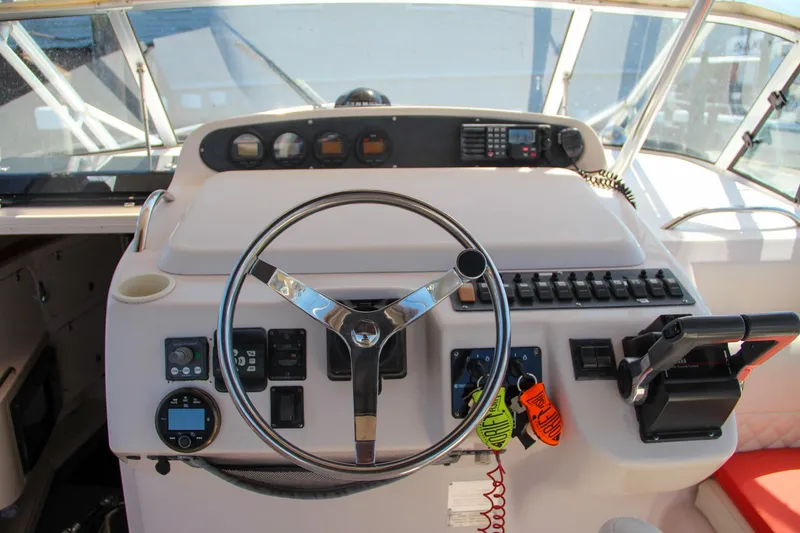 Slide: The Image of 2003 Grady-White Express 330 helm with steering wheel and control panel. - 22