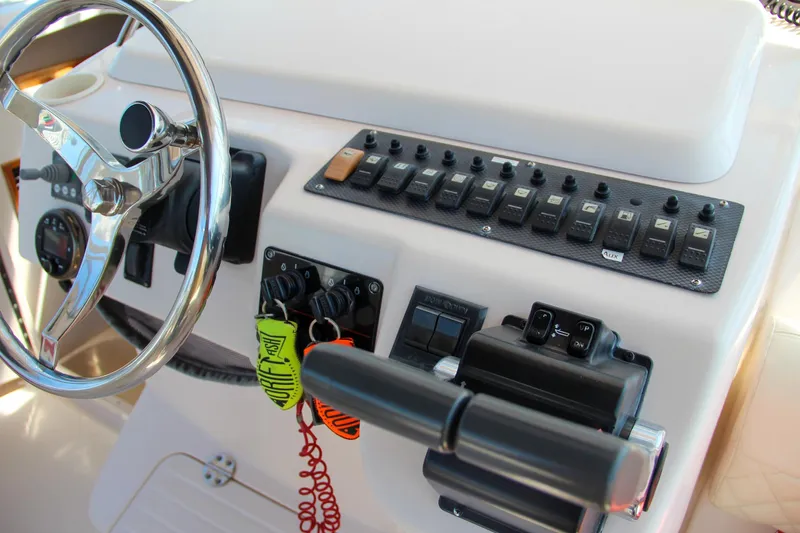 Slide: The Image of 2003 Grady-White Express 330 helm with steering wheel and control panel. - 23