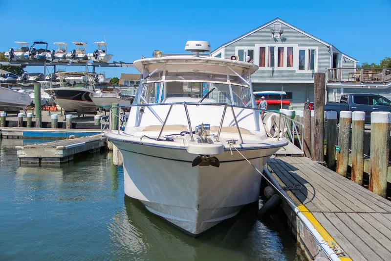 Slide: The Image of 2003 Grady-White Express 330 boat docked at marina, clear blue sky background. - 3