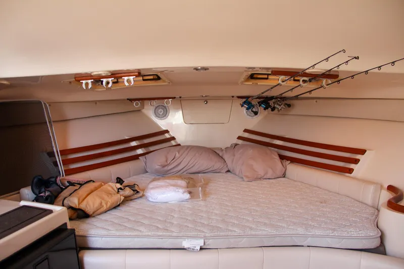 Slide: The Image of 2003 Grady-White Express 330 cabin interior with bed and fishing rods. - 32
