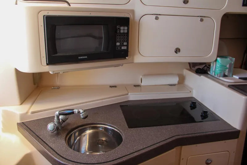 Slide: The Image of 2003 Grady-White Express 330 boat kitchen with sink, stove, and microwave. - 33