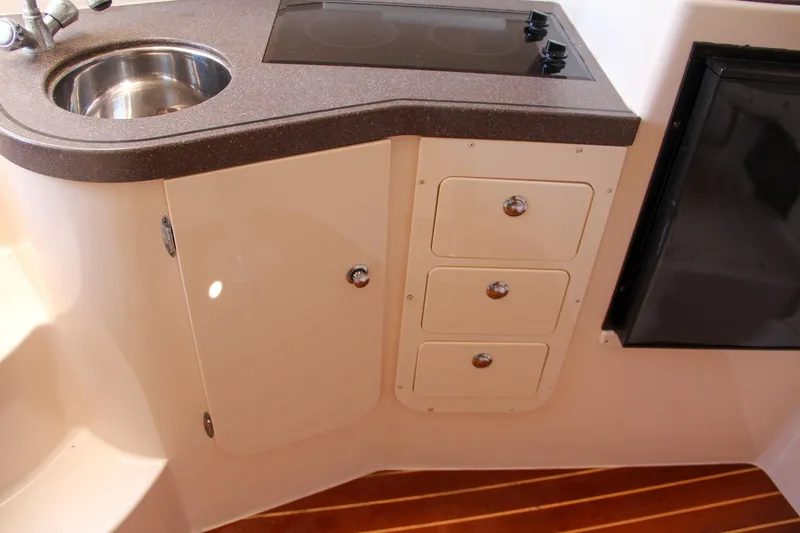 Slide: The Image of 2003 Grady-White Express 330 boat interior with sink, stove, and storage drawers. - 34