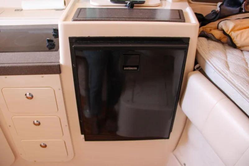 Slide: The Image of 2003 Grady-White Express 330 interior with compact refrigerator and storage drawers. - 36