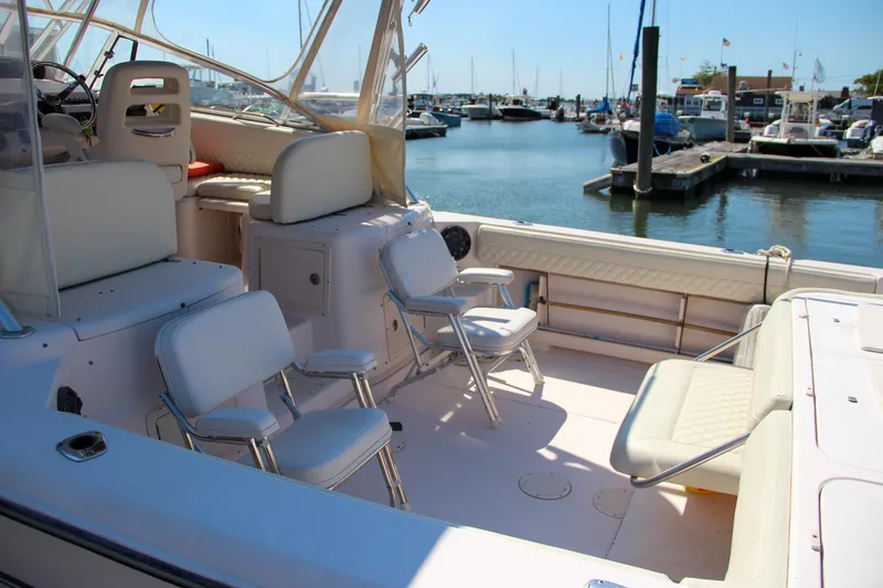 Slide: The Image of 2003 Grady-White Express 330 boat interior at marina, featuring seating and docked boats. - 4