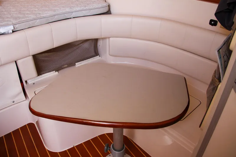 Slide: The Image of 2003 Grady-White Express 330 cabin interior with cushioned seating and table. - 43