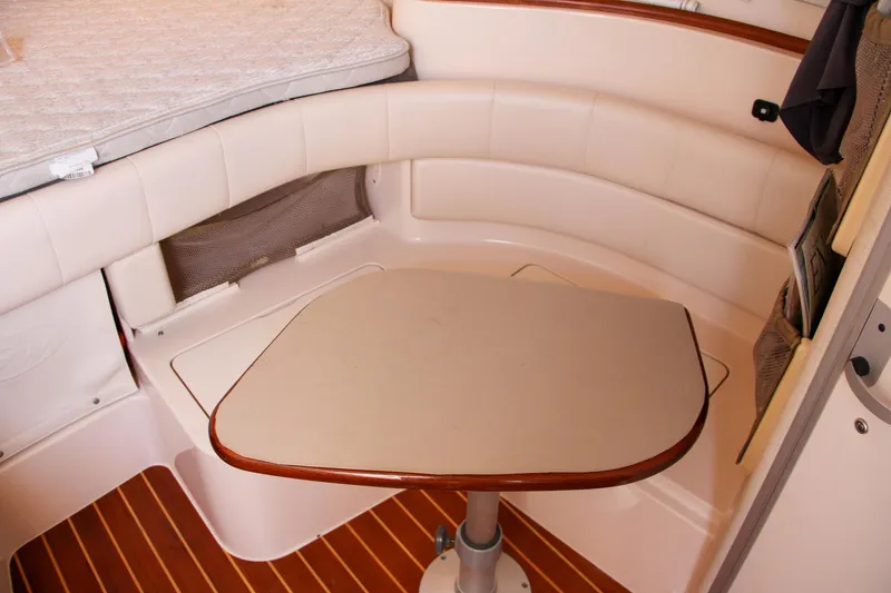 Slide: The Image of 2003 Grady-White Express 330 cabin interior with cushioned seating and table. - 44