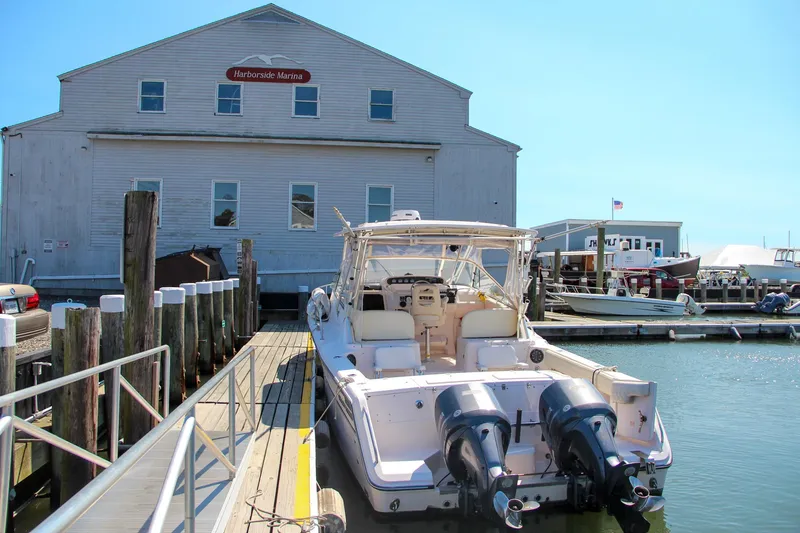 Slide: The Image of 2003 Grady-White Express 330 docked at a marina with a wooden building. - 6