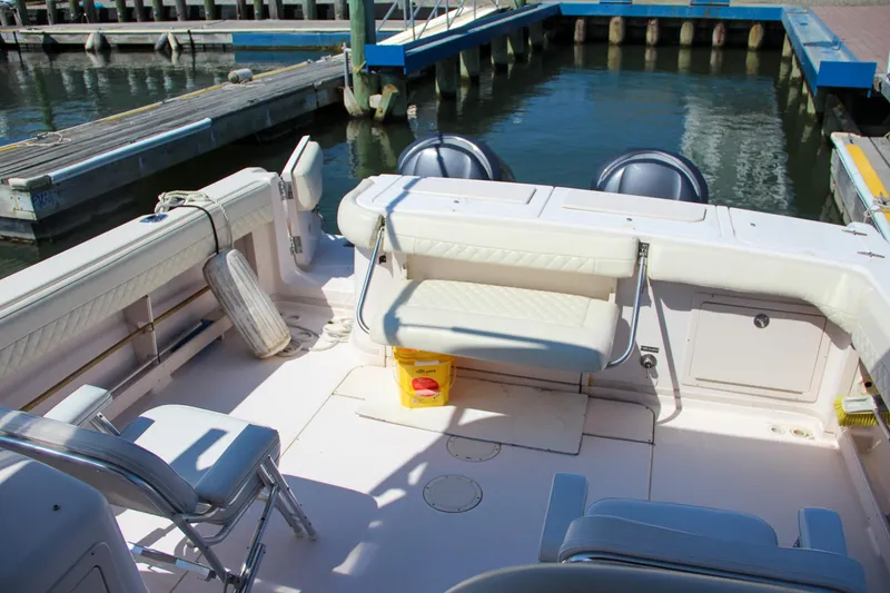 Slide: The Image of 2003 Grady-White Express 330 boat interior at dock, featuring seating and equipment. - 8