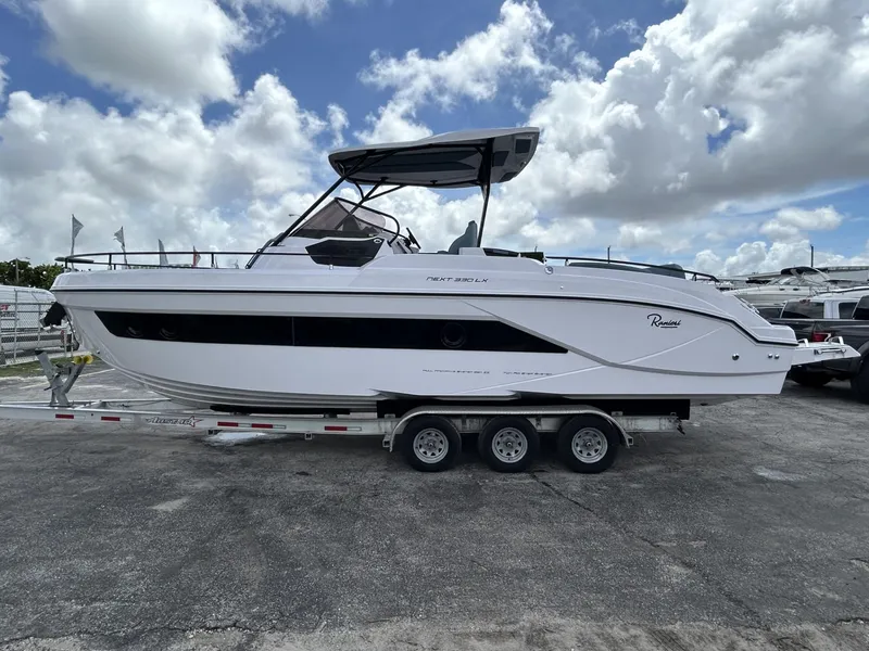 Slide: The Image of 2025 Ranieri 330LX boat on trailer under cloudy sky. - 10