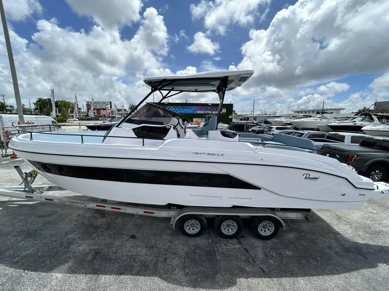 Slide: The Image of 2025 Ranieri 330LX boat on trailer under cloudy sky. - 14