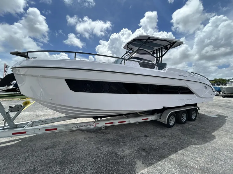 Slide: The Image of 2025 Ranieri 330LX boat on trailer under cloudy sky. - 15