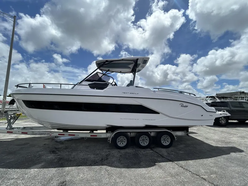 Slide: The Image of 2025 Ranieri 330LX boat on trailer under cloudy sky. - 2