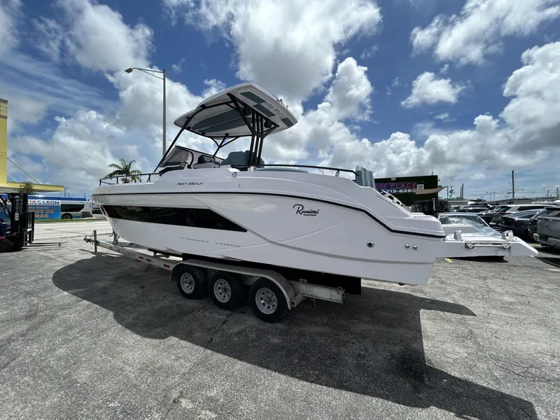 Slide: The Image of 2025 Ranieri 330LX boat on trailer under cloudy sky. - 31