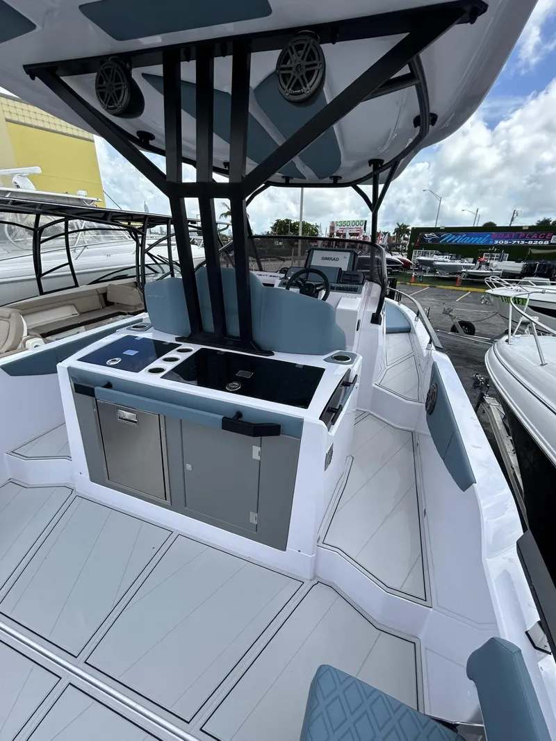 Slide: The Image of 2025 Ranieri 330LX boat interior with modern helm and seating, docked under a cloudy sky. - 35