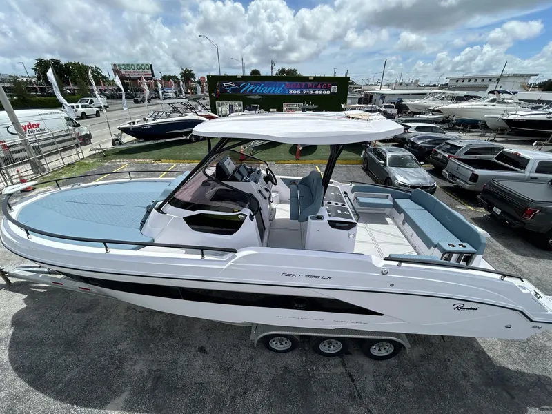 Slide: The Image of 2025 Ranieri 330LX boat on display at a dealership, showcasing sleek design and spacious interior. - 6