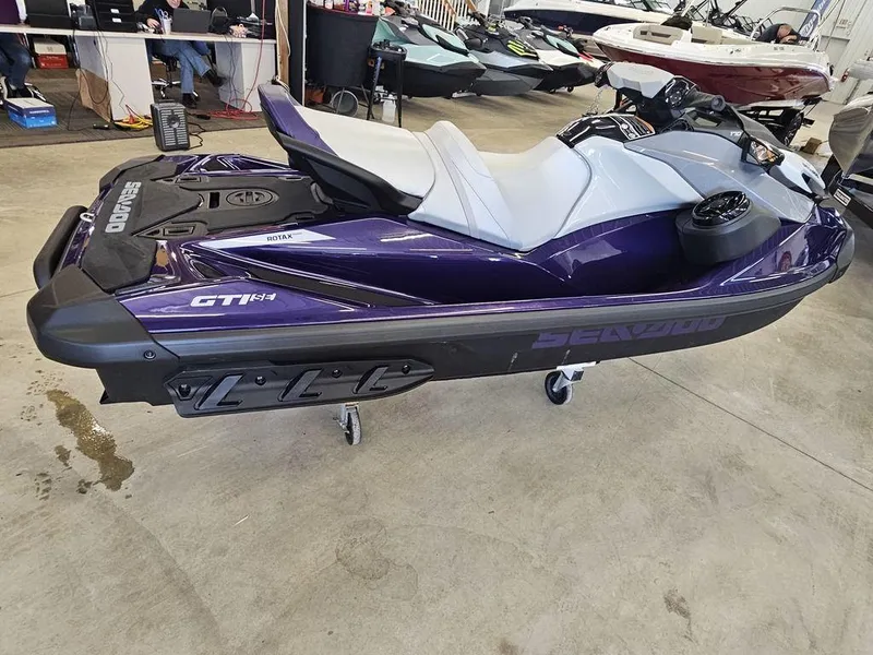 Slide: The Image of 2025 Sea-Doo GTI™ SE 170 jet ski in showroom, featuring Tech, Audio, iDF, iBR systems. - 6