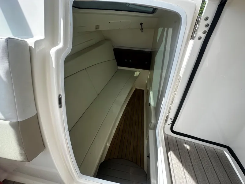 Slide: The Image of Interior cabin of 2016 Boston Whaler 320 Vantage boat, featuring seating and wood flooring. - 10
