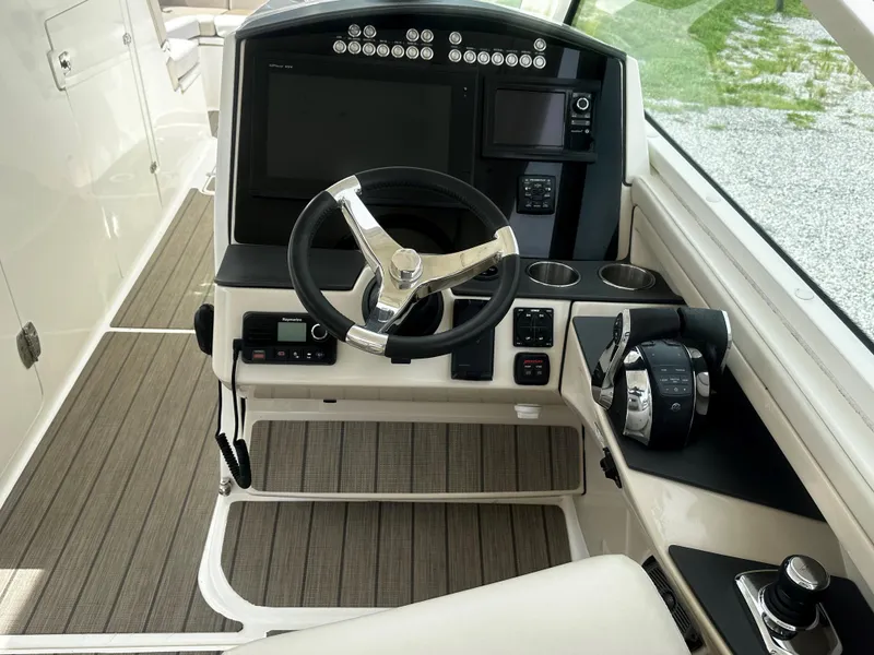 Slide: The Image of 2016 Boston Whaler 320 Vantage helm with modern controls and steering wheel. - 12