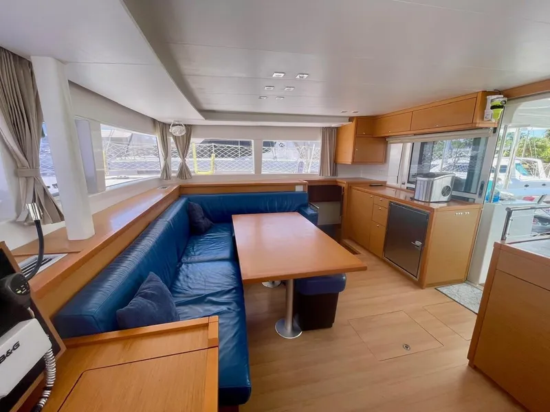 Slide: The Image of Spacious interior of 2015 Lagoon 450 F catamaran with blue seating and wooden finishes. - 34