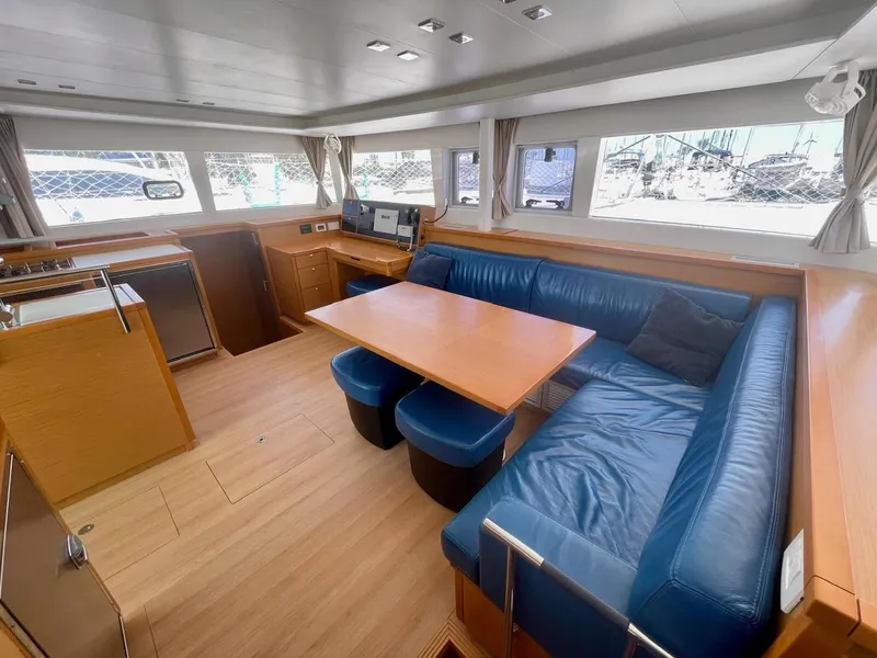 Slide: The Image of Interior of 2015 Lagoon 450 F yacht with blue seating and wooden table. - 36