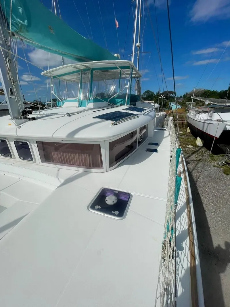 Slide: The Image of 2015 Lagoon 450 F catamaran with turquoise canopy, docked under clear blue sky. - 48
