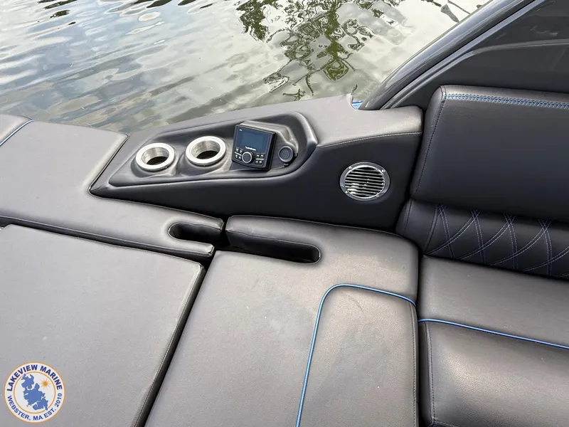 Slide: The Image of 2024 Bennington RX 23 RXSBA boat interior with cup holders and control panel by the water. - 11