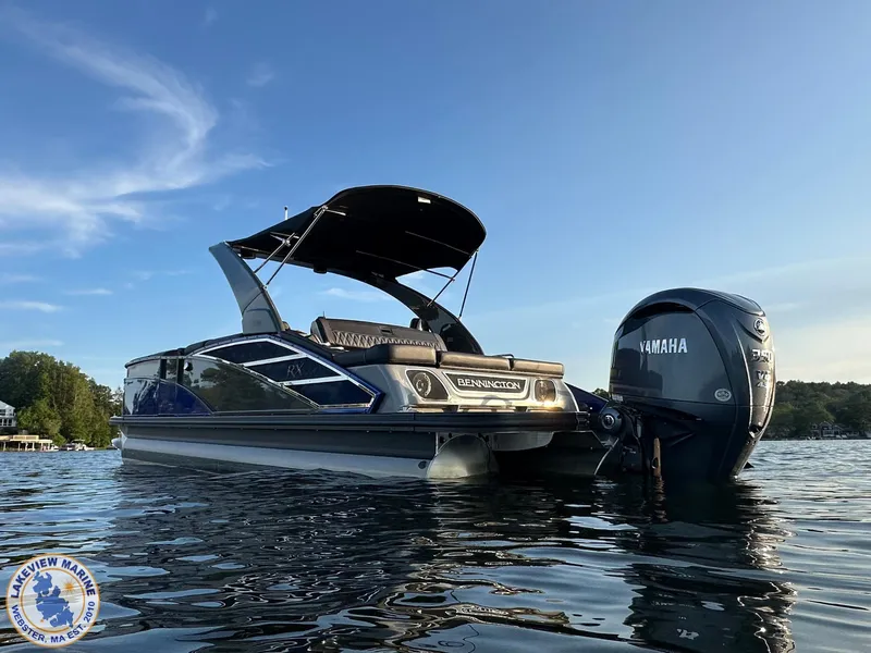 Slide: The Image of 2024 Bennington RX 23 RXSBA pontoon boat with Yamaha engine on a calm lake. - 3