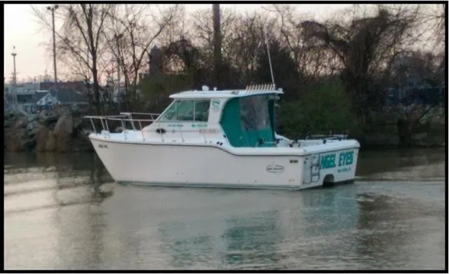 Slide: The Image of 1999 Baha Cruisers 290 King Cat Ht boat on calm water near trees. - 2