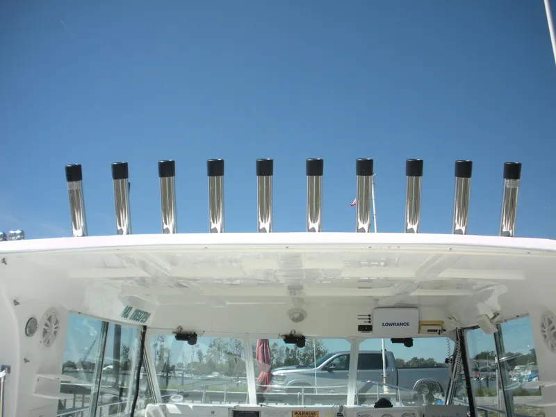 Slide: The Image of 1999 Baha Cruisers 290 King Cat Ht boat with rod holders under clear blue sky. - 6