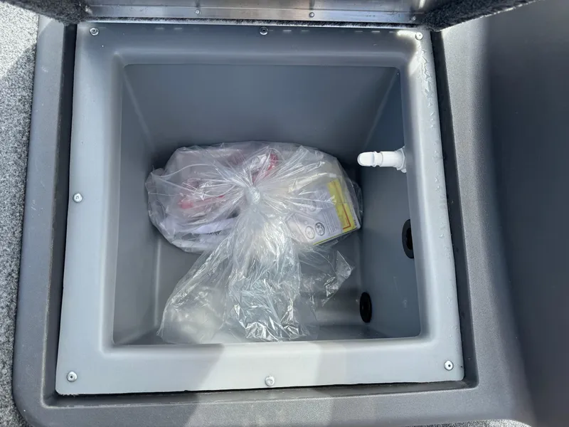 Slide: The Image of 2024 Tracker Bass Tracker Classic XL storage compartment with plastic-wrapped items inside. - 13