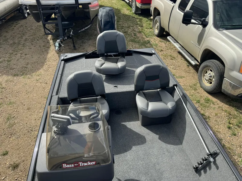 Slide: The Image of 2024 Tracker Bass Tracker Classic XL boat with seating, parked beside a truck. - 15