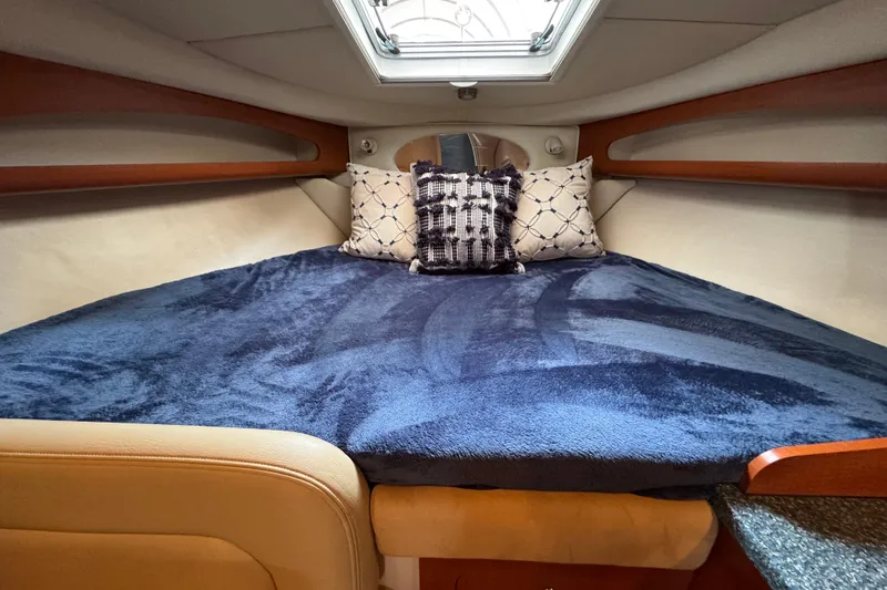 Slide: The Image of 2005 Chaparral Signature 270 cabin interior with cozy bed and decorative pillows. - 14