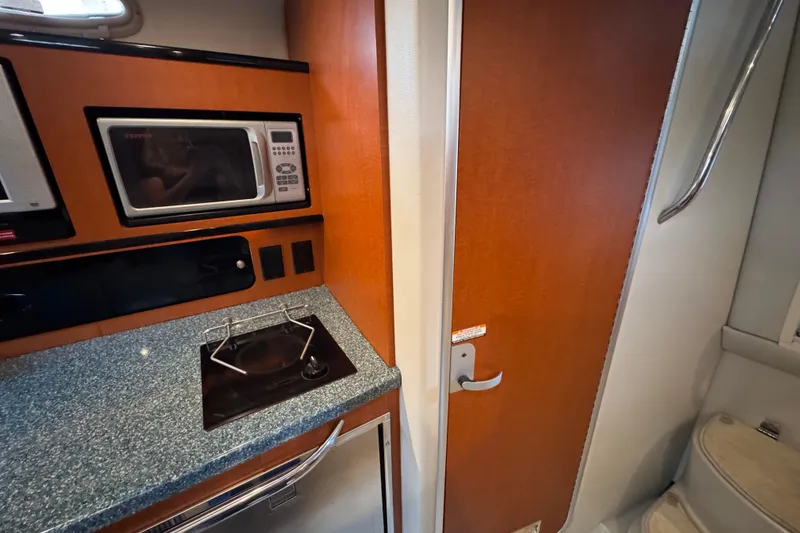 Slide: The Image of 2005 Chaparral Signature 270 interior with microwave, stove, and wooden door. - 16