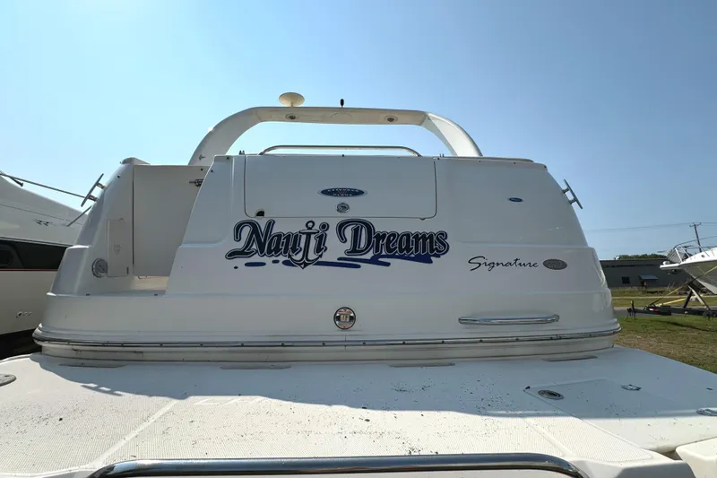 Slide: The Image of 2005 Chaparral Signature 270 boat interior with seating and helm, under covered dock. - 2