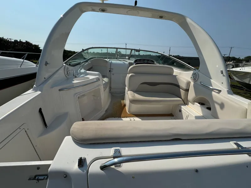 Slide: The Image of 2005 Chaparral Signature 270 boat interior with seating and sink, docked beside another boat. - 3