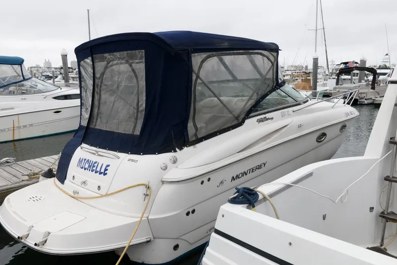 The Image of 2005 Monterey 250 Cruiser docked at marina with blue canopy. - 0