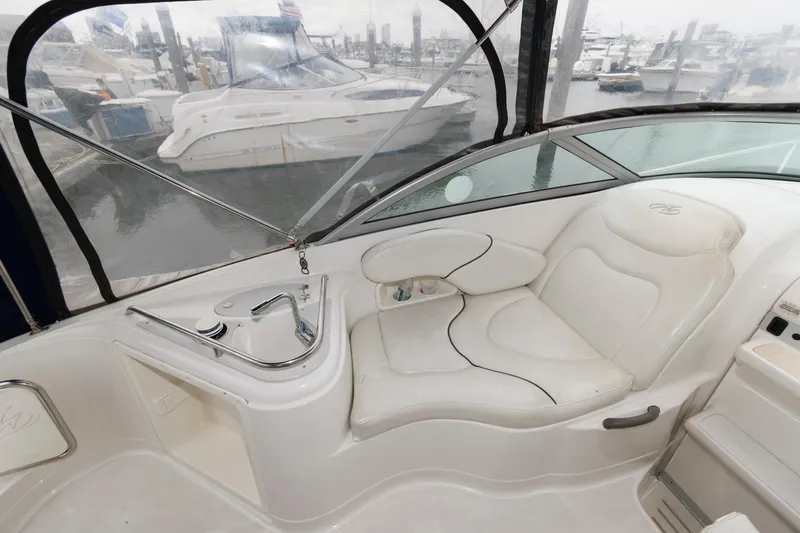 Slide: The Image of 2005 Monterey 250 Cruiser interior with white seating and marina view. - 3