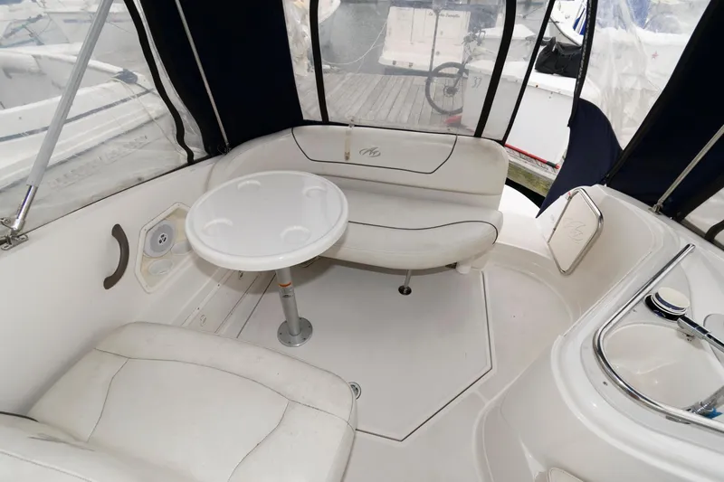 Slide: The Image of 2005 Monterey 250 Cruiser interior with white seating and round table. - 4
