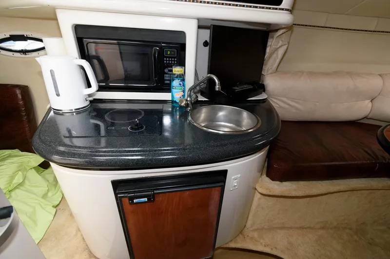 Slide: The Image of 2005 Monterey 250 Cruiser kitchenette with sink, microwave, and kettle. - 8