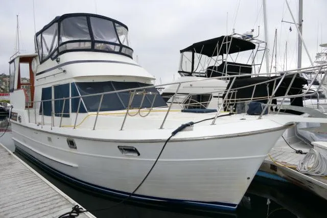 Slide: The Image of 1986 Nova 36 Sundeck yacht docked at marina, featuring spacious deck and covered helm. - 1