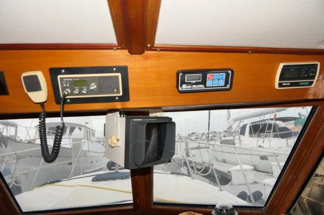 Slide: The Image of Interior view of 1986 Nova 36 SUNDECK boat with navigation equipment and marina background. - 13