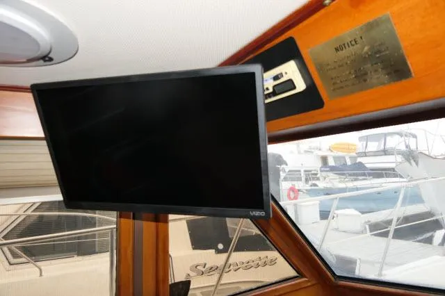 Slide: The Image of Interior of 1986 Nova 36 Sundeck with mounted Vizio TV and marina view. - 16