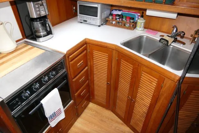 Slide: The Image of Compact kitchen in 1986 Nova 36 SUNDECK boat with stove, sink, and wooden cabinets. - 18