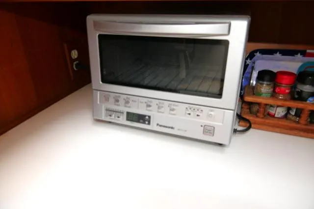 Slide: The Image of Silver Panasonic toaster oven on a white countertop, next to a spice rack. - 20